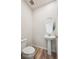 Simple bathroom featuring a toilet, a sink with a pedestal, and wood-look flooring at 1417 Bloom St, Brighton, CO 80601