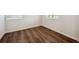 A bright bedroom features dark wood-look flooring, windows, and white trim at 1417 Bloom St, Brighton, CO 80601