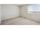 This bedroom offers neutral carpeting and a window for natural light at 1417 Bloom St, Brighton, CO 80601