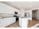 Bright kitchen features stainless steel appliances, quartz counters, white cabinets, and a central island with sink at 1417 Bloom St, Brighton, CO 80601