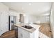 The bright kitchen offers a central island with sink, quartz counters, stainless appliances, and an open floor plan at 1417 Bloom St, Brighton, CO 80601