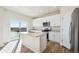 Well-lit kitchen featuring white cabinets, stainless steel appliances, an island, and a sliding glass door at 1417 Bloom St, Brighton, CO 80601