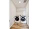 The laundry area has a newer washer and dryer, wood look flooring, and a shelf at 1417 Bloom St, Brighton, CO 80601