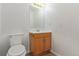 Cozy half-bathroom with a wooden vanity, sleek mirror, and neutral color palette at 7925 York St # 2, Denver, CO 80229
