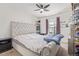 Comfortable bedroom with a tufted headboard bed, ceiling fan, and natural light at 7925 York St # 2, Denver, CO 80229