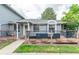 Charming gray home featuring a welcoming front porch with room for seating and a grill at 7925 York St # 2, Denver, CO 80229