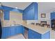 Charming kitchen features blue cabinets, stainless steel appliances, and countertop seating at 7925 York St # 2, Denver, CO 80229