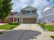 Charming two-story home with a two-car garage, concrete driveway and manicured lawn at 20768 Randolph, Denver, CO 80249