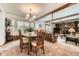 Cozy dining area with window seat, decorative chandelier, and living room fireplace at 678 S Oswego Ct, Aurora, CO 80012