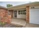 Covered front porch with brick columns leads to the front door and attached garage at 678 S Oswego Ct, Aurora, CO 80012