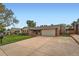 Wide view of the brick house with a driveway, a two car garage and a green lawn at 678 S Oswego Ct, Aurora, CO 80012