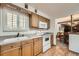 Eat-in kitchen features wood cabinetry, white appliances, and hardwood floors at 678 S Oswego Ct, Aurora, CO 80012