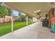 This covered patio with ceiling fans overlooks a grassy backyard with a wood fence at 678 S Oswego Ct, Aurora, CO 80012