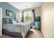 Cozy bedroom featuring blue accent wall, queen bed, and large window at 9390 W Chatfield Pl # 104, Littleton, CO 80128