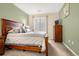 Bedroom featuring a wooden bed frame, a window with blinds, and an accent wall at 9390 W Chatfield Pl # 104, Littleton, CO 80128