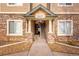 Covered entrance featuring stone accents and wooden staircase, offers a welcoming feel to the condos at 9390 W Chatfield Pl # 104, Littleton, CO 80128