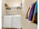 Functional laundry room with white washer and dryer, storage shelves, and coat rack for added convenience at 9390 W Chatfield Pl # 104, Littleton, CO 80128