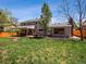 Spacious backyard featuring a large lawn, patio area with furniture and a covered outdoor seating area at 6953 S Prescott St, Littleton, CO 80120
