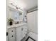 Bright bathroom with a white vanity, marble countertops, a large mirror, and tub at 6953 S Prescott St, Littleton, CO 80120