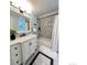 Updated bathroom with marble countertop, white vanity, and tiled shower-tub surround at 6953 S Prescott St, Littleton, CO 80120