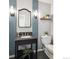 Stylish half-bath with a black vanity, granite countertop, blue backsplash, and modern lighting at 6953 S Prescott St, Littleton, CO 80120