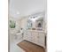 Bathroom with double vanity, marble backsplash, modern lighting, and a woven rug at 6953 S Prescott St, Littleton, CO 80120
