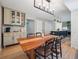 Open dining space showcasing a wooden table, bar-cabinetry, stairs and views to the kitchen at 6953 S Prescott St, Littleton, CO 80120
