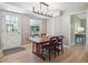 Sunny dining room with a wooden table, stylish lighting, and a back door to the exterior at 6953 S Prescott St, Littleton, CO 80120