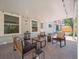Covered backyard patio featuring comfortable outdoor seating, brick pavers and decorative string lights at 6953 S Prescott St, Littleton, CO 80120