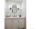 Updated powder room with oval mirror, decorative sconces, quartz countertop and dark fixtures at 6953 S Prescott St, Littleton, CO 80120