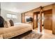 Bedroom with wood paneling, carpet and access to office and a set of built-in cabinets at 9309 Highland Pl, Arvada, CO 80002