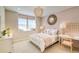 Softly lit bedroom with a cozy window seat, complemented by pink accents and decorative wall art at 8576 Hotchkiss St, Littleton, CO 80125