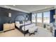 Modern bedroom with a dark accent wall, canopy bed, bench, and large windows offering scenic views at 8576 Hotchkiss St, Littleton, CO 80125
