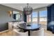 Elegant dining room with modern chandelier, stylish buffet, and large windows framing a picturesque landscape at 8576 Hotchkiss St, Littleton, CO 80125