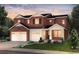 Inviting three-car garage home with a combination of white brick and brown wooden accents, landscaped front yard at 8576 Hotchkiss St, Littleton, CO 80125