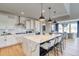Bright kitchen featuring a large island with seating, modern appliances, and an adjacent dining area with scenic views at 8576 Hotchkiss St, Littleton, CO 80125