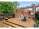 Inviting back deck with an outdoor dining set, a brick home exterior, and stepping stones for cozy entertaining at 1602 Garfield St, Denver, CO 80206