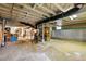 Unfinished basement with exposed pipes, painted floor, and storage at 1602 Garfield St, Denver, CO 80206