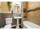 Bathroom features decorative tile, plants, and a pedestal sink at 1602 Garfield St, Denver, CO 80206