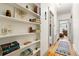 Hallway features hardwood floors, built in shelves, and an adjoining bathroom and bedroom at 1602 Garfield St, Denver, CO 80206