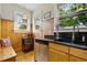 Compact kitchen area features stainless steel appliances, wood paneling, and bright windows at 1602 Garfield St, Denver, CO 80206