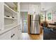 Charming kitchen with bright white cabinets, modern stainless steel refrigerator, and rustic hardwood flooring at 1602 Garfield St, Denver, CO 80206