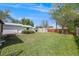 Large, grassy backyard with mature trees and outbuildings at 310 Jay St, Lakewood, CO 80226