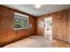 Cozy bedroom featuring wood paneled walls, a large window and hardwood floors at 310 Jay St, Lakewood, CO 80226