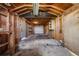 Garage interior with exposed beams, concrete floor, and an open door, showcasing a spacious area for vehicle storage at 310 Jay St, Lakewood, CO 80226