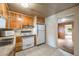Compact kitchen featuring standard appliances, tiled floors, and light wood cabinetry at 310 Jay St, Lakewood, CO 80226