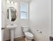 Well-lit half-bath with a pedestal sink, oval mirror, and a toilet at 1222 Penner Dr, Erie, CO 80026