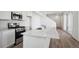 Close up of kitchen featuring white cabinets, quartz countertop island, and stainless steel appliances at 1222 Penner Dr, Erie, CO 80026