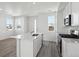 Kitchen with island opens up to the living space, featuring white cabinets and stainless steel appliances at 1222 Penner Dr, Erie, CO 80026