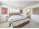 Light-filled bedroom featuring eclectic artwork, a bed, and ensuite at 19197 E 64Th Ave, Denver, CO 80249